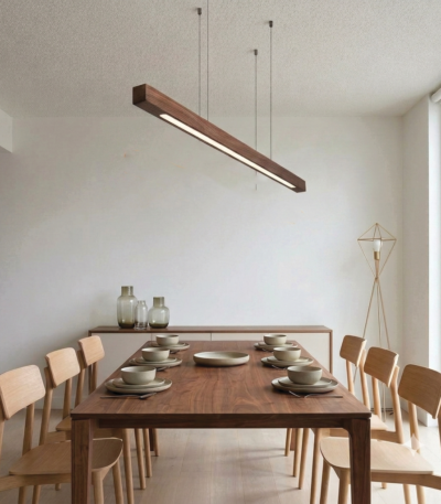 Modern wooden linear pendant light hanging above a dining table in a minimalist interior, featuring a natural wood finish and warm LED lighting.
